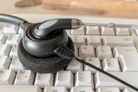 Headset for phone on the computer keyboard both dirty Stock Photos