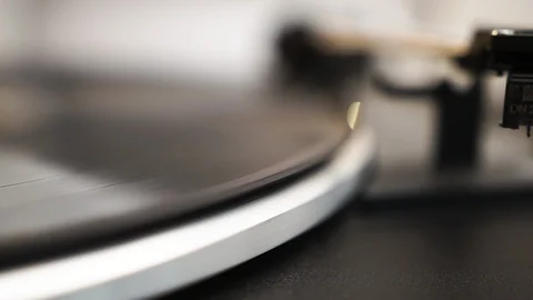 The headshell of a vinyl player moves over a spinning vinyl, drops down 動画素材 103563997