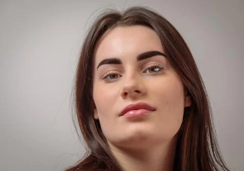 Headshot of beautiful model posing with long brown hair and defined eyebrows  Stock Photos