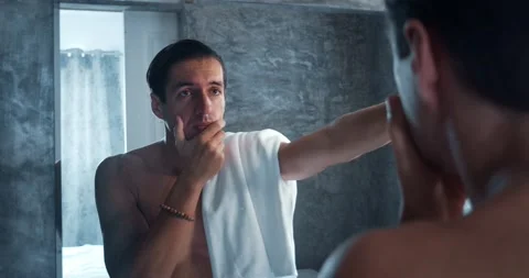 Headshot of depressed young man looking in the bathroom mirror. Depressed man Stock Footage 231741504