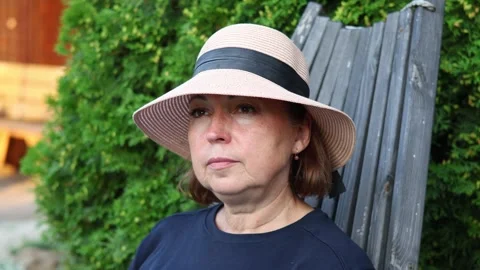 Headshot profile of pretty middle aged woman in the hat in the garden Stock Footage 288242093