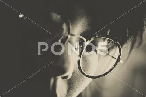 Headshot of women with round glasses looking downward concentrate on somethin Stock Photos