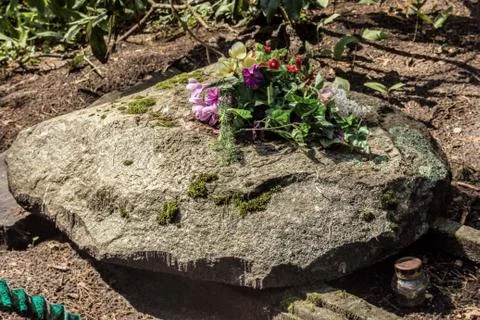 Headstone with artificial flowers Stock Photos