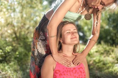 Healer demonstrates refreshing massaging methods on the grass of the forest. Stock Photos