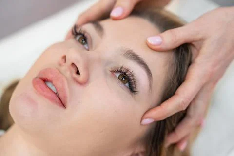 Healer performing set of 32 points of access bars on young woman head Stock Photos