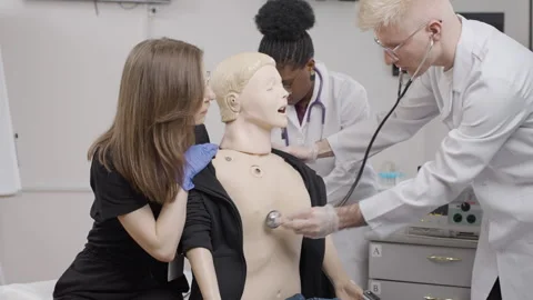 Healing hands: foreign students practicing first aid on mannequin Stock Footage 275369142