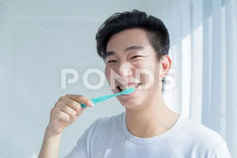 Health And Beauty Concept - Smiling Young Man With Toothbrush