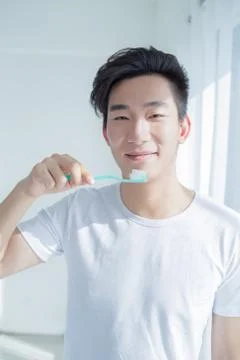 Health and beauty concept - smiling young man with toothbrush Stock Photos