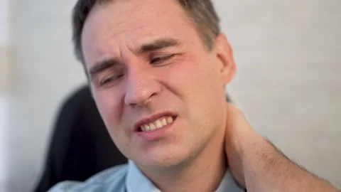 Health problems from sedentary work. a man in a shirt is holding on to a sore Stock Footage 298206227