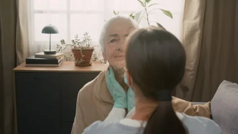 Health Worker Using Circular Motion to Feel Lymph Nodes in Elderly Womans Neck Stock Footage 329179844