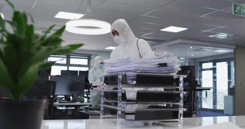 Health worker wearing protective clothes cleaning the office using disinfectant Stock Footage