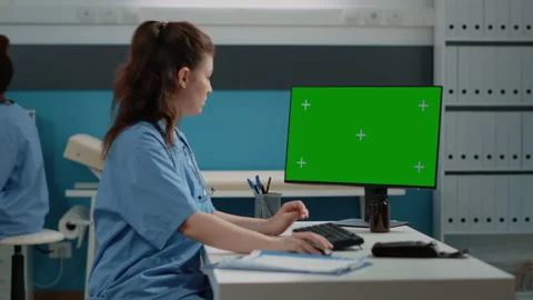 Healthcare assistant using computer for horizontal green screen Stock Footage 163429895