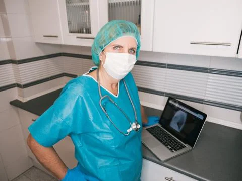 Healthcare professional woman with protection against covid 19 using computer Stock Photos