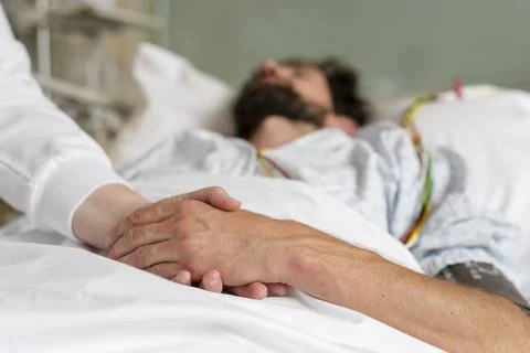 Healthcare staff caring for a patient in hospital bed Stock Photos