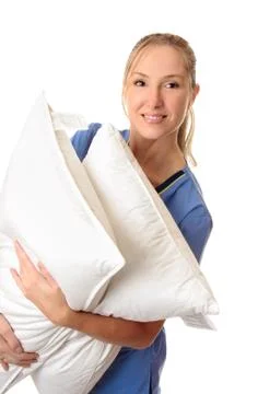 Healthcare worker carrying patient pillows Stock Photos