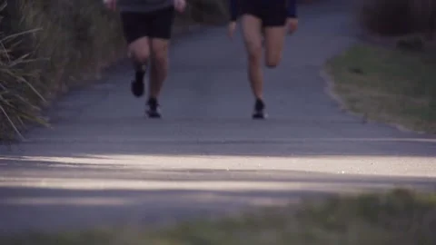 Healthy &amp; active couple running / jogging in slow motion in a park Stock Footage 132235886