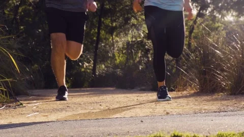 Healthy &amp; active couple running / jogging in slow motion in a park Stock Footage 132236005