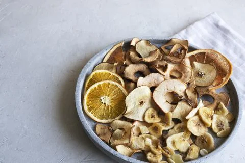 Healthy after dinner snacks, fruit chips in a gray concrete plate.. Stock Photos