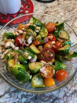 Healthy, appetizing brussels sprouts cold salad with tomatoes and onions Stock Photos