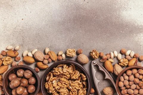 Healthy assorted nuts with nutcracker on stone surface Stock Photos