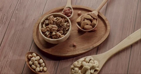 Healthy assorted nuts spinning on a wooden table Stock Footage 344322034