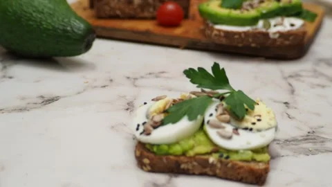Healthy avocado toasts with rye bread, sliced avocado, eggs, cottage Stock Footage 272158904