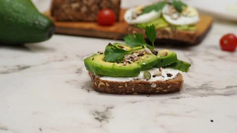 Healthy avocado toasts with rye bread, sliced avocado, eggs, cottage Stock Footage 272158906