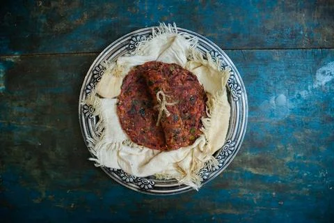 Healthy Beetroot Flatbread or Paratha in a silver plate on a blue wooden table. 스톡 사진