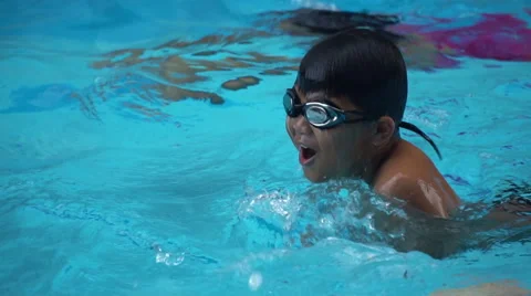 Healthy boy breast stroke swims slow motion in swimming pool Stock Footage