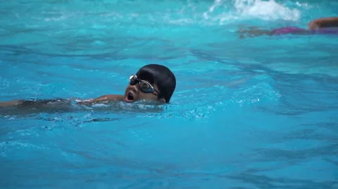 Healthy boy front crawl swims slow motion in swimming pool Stock Footage