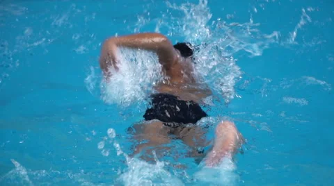 Healthy boy front crawl swims slow motion in swimming pool Stock Footage