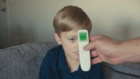 Healthy boy having temperature checked with infrared thermometer Stock-Footage 346969670