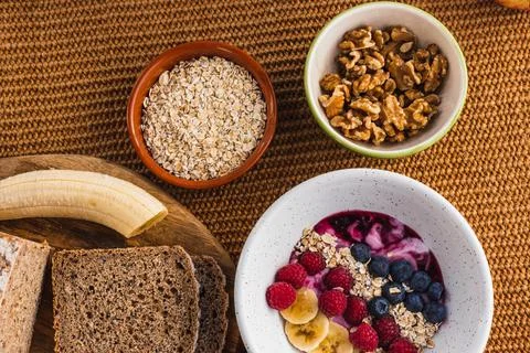 Healthy breakfast with brown bread, nuts and a fruit bowl Stock Photos