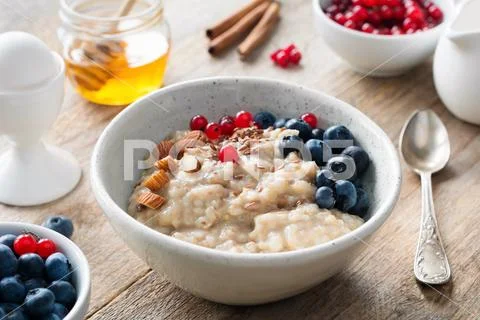 Healthy breakfast food oatmeal porridge, boiled egg, honey and berries. Stock-Fotos