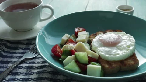 Healthy breakfast. fried egg on toast bread  fresh salad and cup of tea Stock Footage 101747481