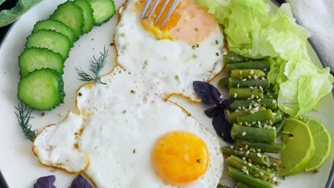 A healthy breakfast of fried eggs with a high content of green vegetables. On a Stock Footage 220197436