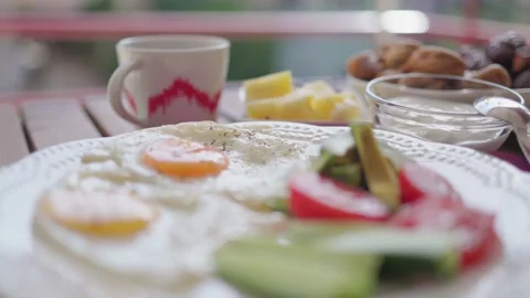 Healthy breakfast with fried eggs, vegetables, fruit, dairy and nuts on table Stock Footage 193986087