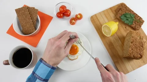 Healthy breakfast. A man eats scrambled eggs and drinks coffee. Top view Stock Footage 99664920