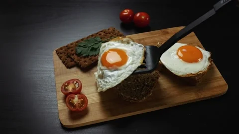 Healthy breakfast. A man is putting scrambled eggs on a fresh grain bread Stock Footage 99656090