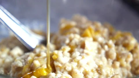 Healthy Breakfast - Oatmeal with Pouring Honey Close-up Stock Footage