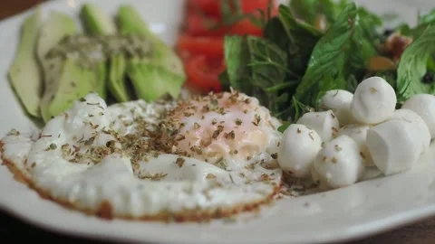 Healthy Breakfast Plate with Fried Egg, Avocado, and Mozzarella 스톡 동영상 346666165