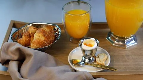 Healthy breakfast setup includes silver egg holder, golden spoon, freshly baked Stock Photos