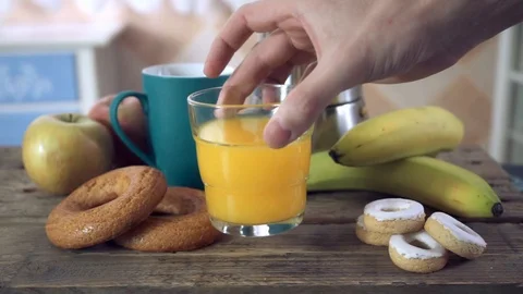 Healthy breakfast swapping a coffee mug by a glass of orange juice Stock Footage 102067604