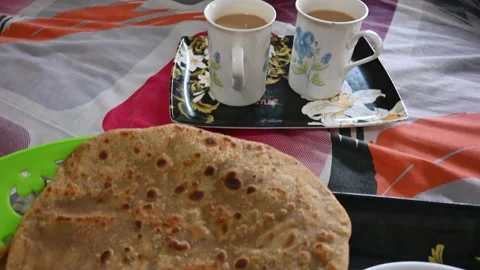 Healthy breakfast with two parathas bread with one egg and two cups full of tea Stock Footage 157473799
