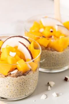 Healthy chia pudding with mango and coconut pieces in a glass for a nutriti.. Stock Photos