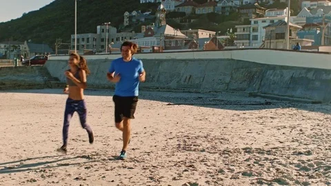 Healthy couple running on beach Stock Footage 76520455