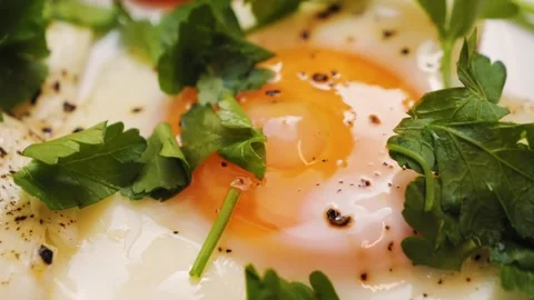 A healthy delicious breakfast consisting of fried eggs seasoned with fresh Stock Footage 314819661