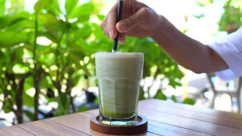 Healthy delicious refreshing plant based drinks on a sunny day. Close up of hand Stock Footage 154922526