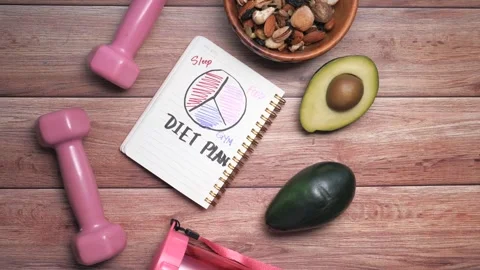 Healthy diet plan with pink dumbbells bowl of mixed nuts and fresh avocados.. Stock Footage 332776973