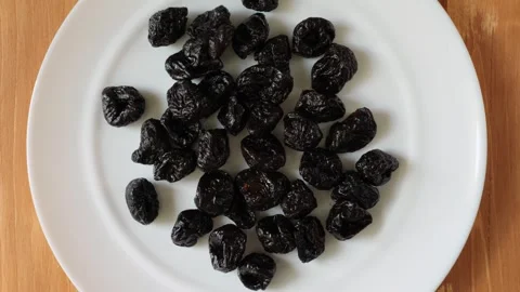 Healthy dried prunes rotating on a white plate Stock Footage 337011860